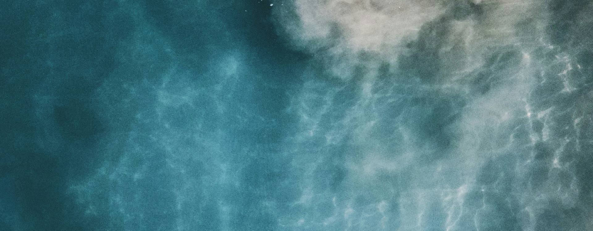 Soft light moving across blue-green ocean water, seen from above